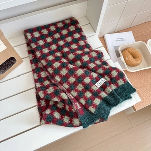 Détail d'une écharpe en maille de laine à carreaux avec étiquette sur fond en bois