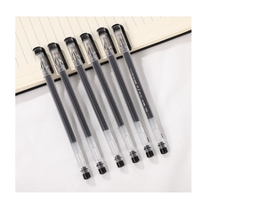 Detail of six transparent gel pens with needle tips and black ink on a lined notebook
