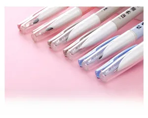 Detail of macaron-colored utility knife pens with protective caps on a pink background