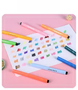Vibrant triangular watercolor marker set scattered on a drawing paper with pink background