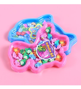 Macro view of assorted mini animal-shaped erasers inside a cute pink dinosaur container