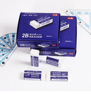 Close-up of white 2B erasers with blue paper sleeves arranged with stationery tools