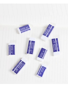 Macro shot of 2B white soft erasers with blue sleeves on lined paper texture