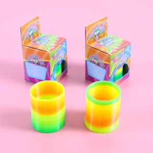 Set of colorful gradient rainbow spring toys with cartoon packaging on pink background