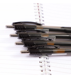 Close-up of 4 retractable black gel pens 0.5mm placed on a white spiral notebook