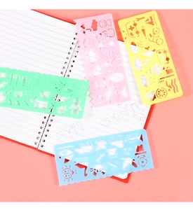 Detailed view of four colorful plastic drawing stencils on a white notebook page