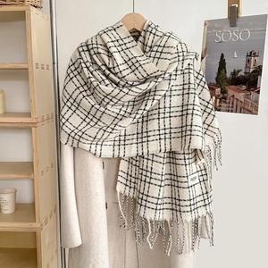 Classic black and white checkered cashmere-like scarf with fringe on a beige coat