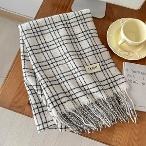 Detail of classic black and white plaid scarf with fringe edges and DODO brand label