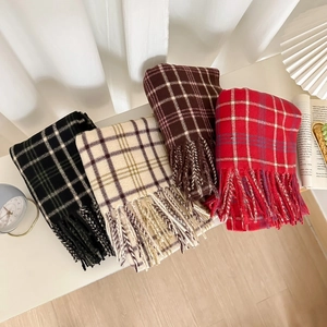 Classic plaid tassel scarves in various colors displayed in a cozy home setting