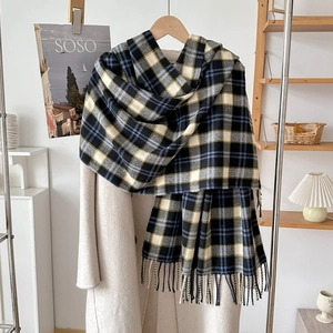 Detailed close-up of blue and beige plaid scarf with soft tassels on a hanger
