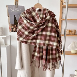 Detail of plaid scarf with tassels on wool coat featuring soft brown and pink cashmere feel