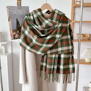 Close-up of soft plaid scarf with fringe details styled on a beige wool coat