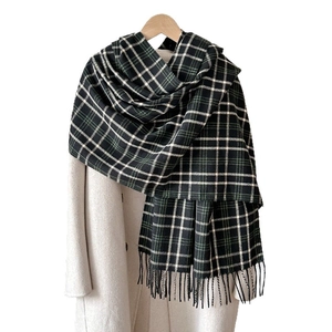 Classic plaid cashmere-feel scarf with fringes styled on a coat for a winter look