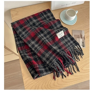 Close-up of soft knit plaid scarf texture with classic red and grey patterns and tassels