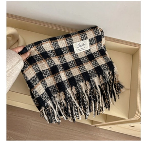Close-up of thick plaid cashmere scarf featuring soft texture and decorative tassels
