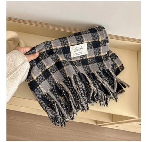 Close-up of soft plaid scarf showing grey yellow check pattern and long tassels