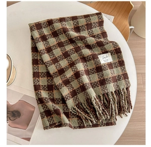 Detail of checkered cashmere-like scarf with fringe and minimalist fabric label