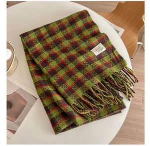 Close-up of checkered cashmere-feel scarf featuring fringe details and decorative label