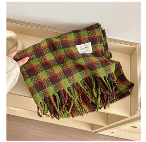 Close-up of soft plaid scarf featuring green-brown checkered pattern and fringe details
