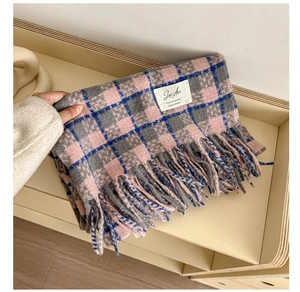 Detail of pink, grey and blue plaid scarf showing soft cashmere-like texture and fringe