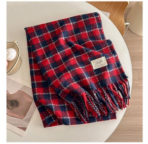 Detail of red and blue plaid scarf showing thick cashmere texture and fringed tassels