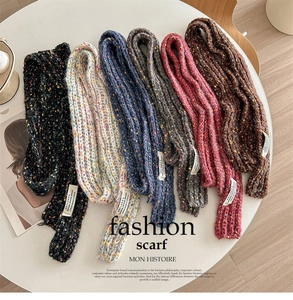 Selection of speckled knit scarves in six colors with brand labels on a wooden floor