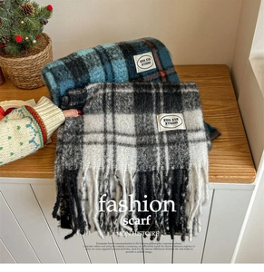 Détail d'écharpes à carreaux en mohair avec pompons et étiquettes dans un décor d'hiver