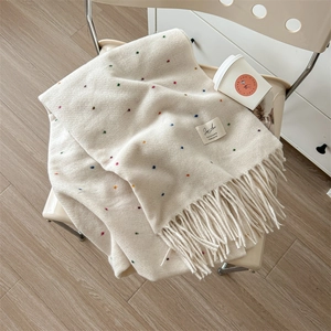 Creamy white knit scarf with colorful polka dots and fringe, warm autumn winter style
