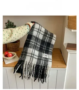 Gros plan détaillé d'une écharpe en mohair à carreaux épais avec franges et étiquette