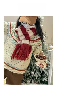 Detail of red and white striped knit scarf with tassels paired with a patterned sweater