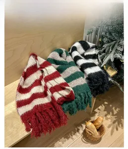 Close-up of thick striped knit scarves with long tassels in a cozy winter setting
