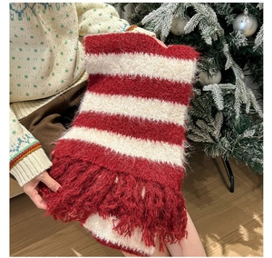 Close-up of red and white striped knit scarf with soft fluffy texture and long tassels