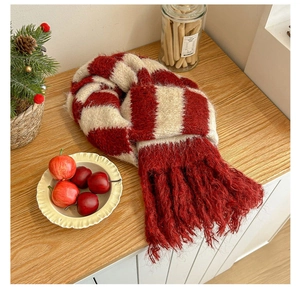 Close-up of thick red and white striped knit scarf featuring long fringe tassels