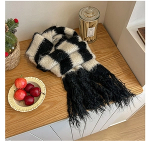 Close-up of black and white checkered knit scarf with long tassels and soft texture