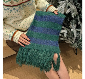 Close-up of thick green and blue striped knit scarf with long fringe and soft texture