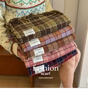 Detail view of colorful vintage plaid scarves with tassel edges and premium woven texture