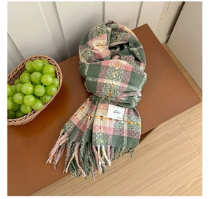 Detail of colorful plaid scarf with vintage logo tag and fringes on a wooden bench