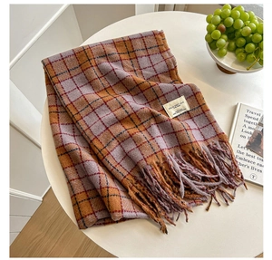 Detail of orange and purple plaid scarf with soft fringe and stylish woven label