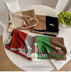 Detail von Strickschals mit Blockfarben und 100% Woll-Label auf einem weißen Tisch