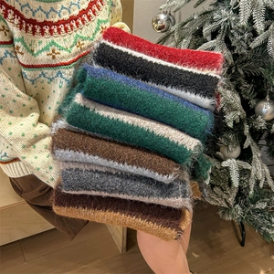 Colorful plush striped knit winter scarf with soft tassels in festive Christmas theme