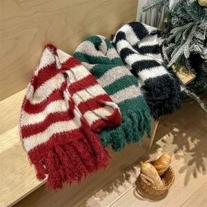 Cozy striped knit scarves with tassels in festive colors on wooden steps for winter