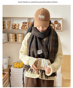 Close-up of a brown plaid scarf and Malibu embroidered cap set in a cozy cafe