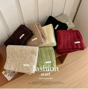 Close-up of cable knit textures on colorful winter scarves with vegetable woven labels