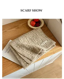 Détail de la maille torsadée d'une écharpe d'hiver beige de haute qualité sur bois