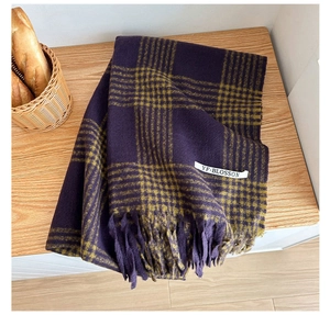 Detailed view of soft plaid cashmere scarf with fringes and woven brand label