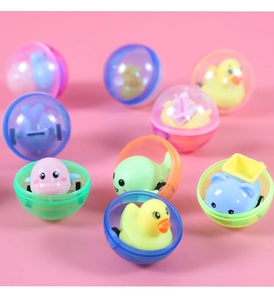 Gros plan de voitures jouets en forme d'animaux colorés dans des œufs gashapon translucides