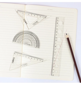 Macro view of four-piece clear plastic geometry ruler set on a notebook page