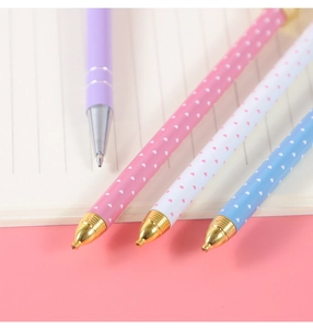 Detail of colorful mechanical pencils with heart prints on a notebook and pink background