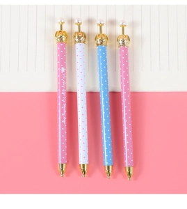 Close-up of crown-top mechanical pencils with gold tips and pearls on a notebook