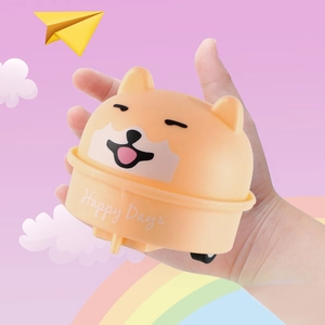 Close-up of cute cartoon dog pull-back toy car being held by hand with colorful background